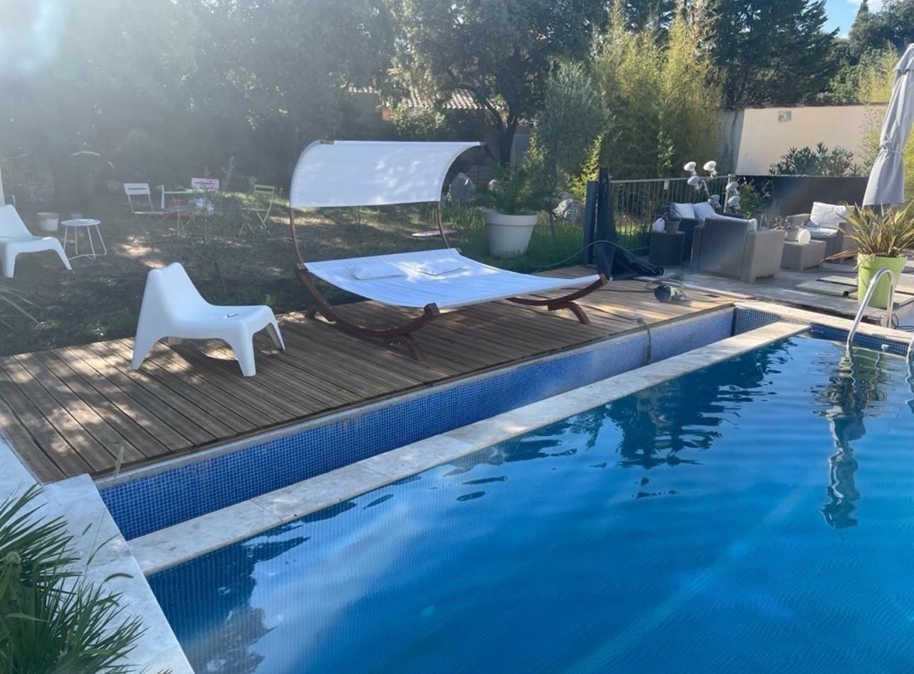 Plage en bois avec transat double et chaises design